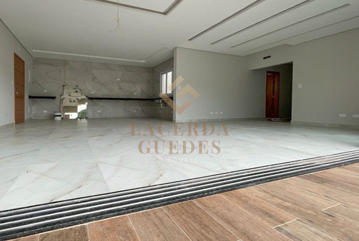 Ambiente social da cobertura com piso claro e varanda
