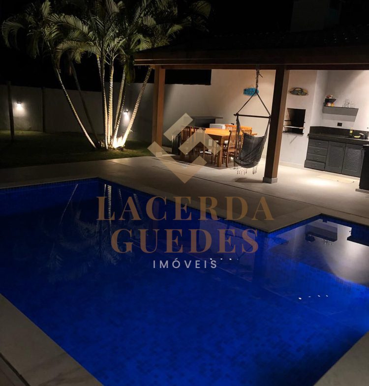 Piscina e área externa da casa à noite