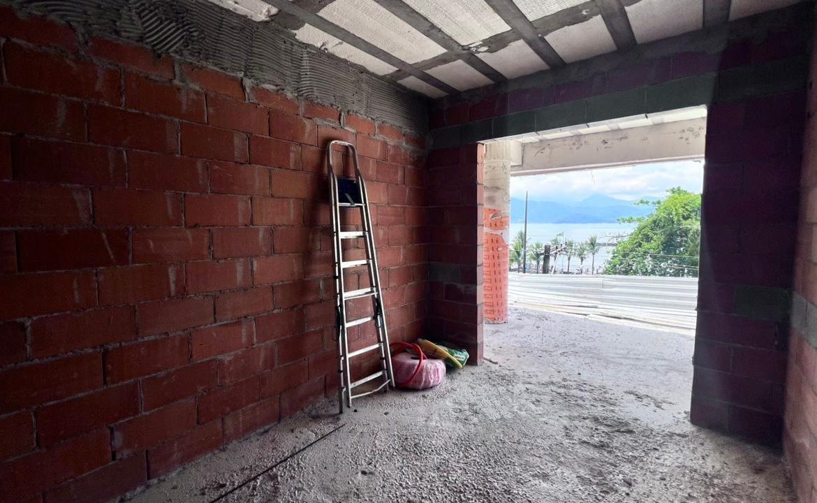 Área interna em obra com abertura voltada para o mar