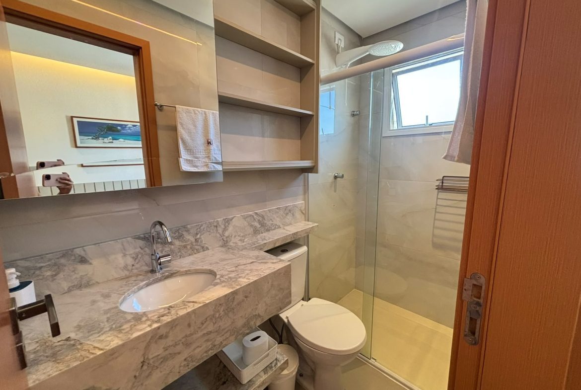 Banheiro do apartamento com bancada e box