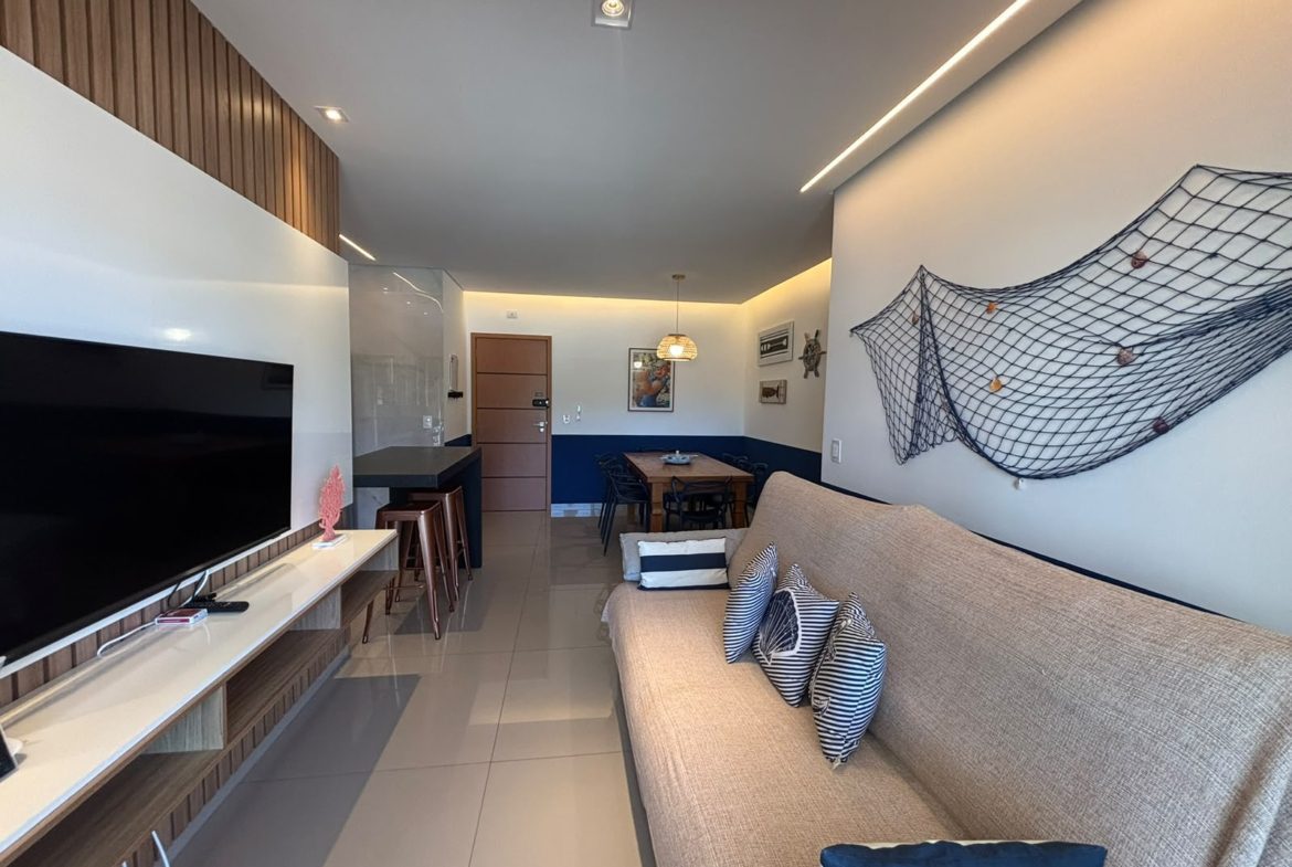 Sala de estar com painel de TV do apartamento no Itaguá