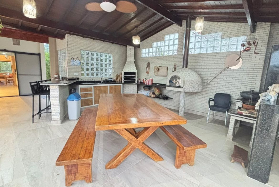 Espaço gourmet com mesa e churrasqueira