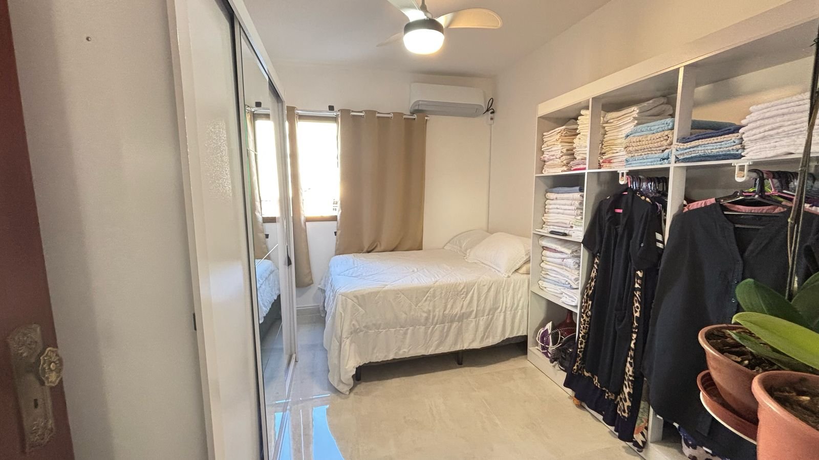 apartamento-centro-ubatuba-sala-sacada (17) Dormitório com armários e área de circulação