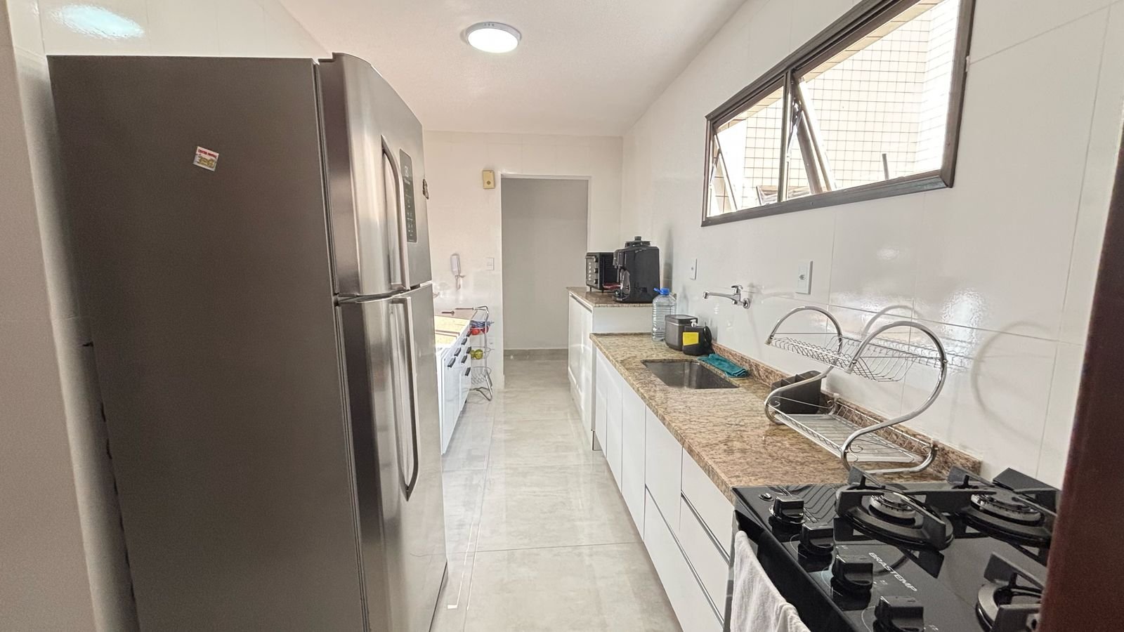 apartamento-centro-ubatuba-sala-sacada (2) Cozinha com bancada e circulação lateral