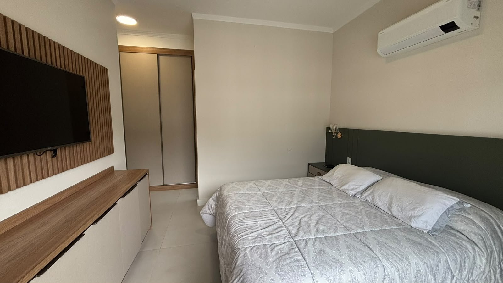 apartamento-praia-enseada-70-metros-mar (13) Dormitório mobiliado com ar-condicionado