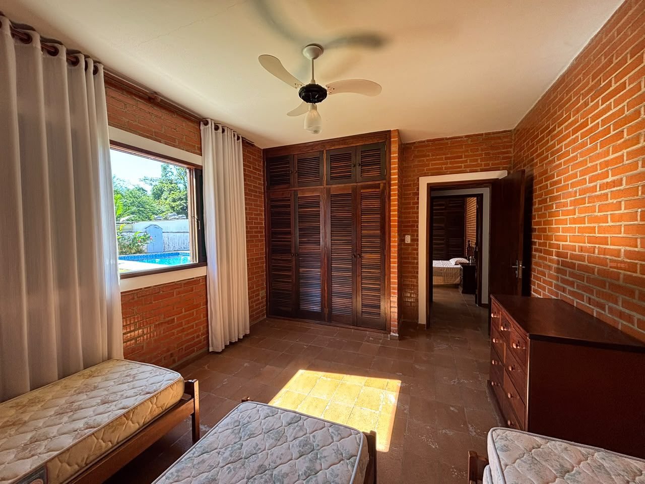casa-centro-ubatuba-piscina (11) Quarto com janela voltada para a área externa