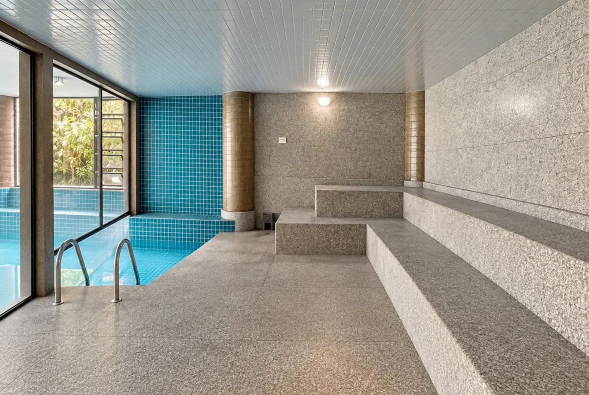 Área da piscina integrada à sauna no condomínio Duo Itaguá