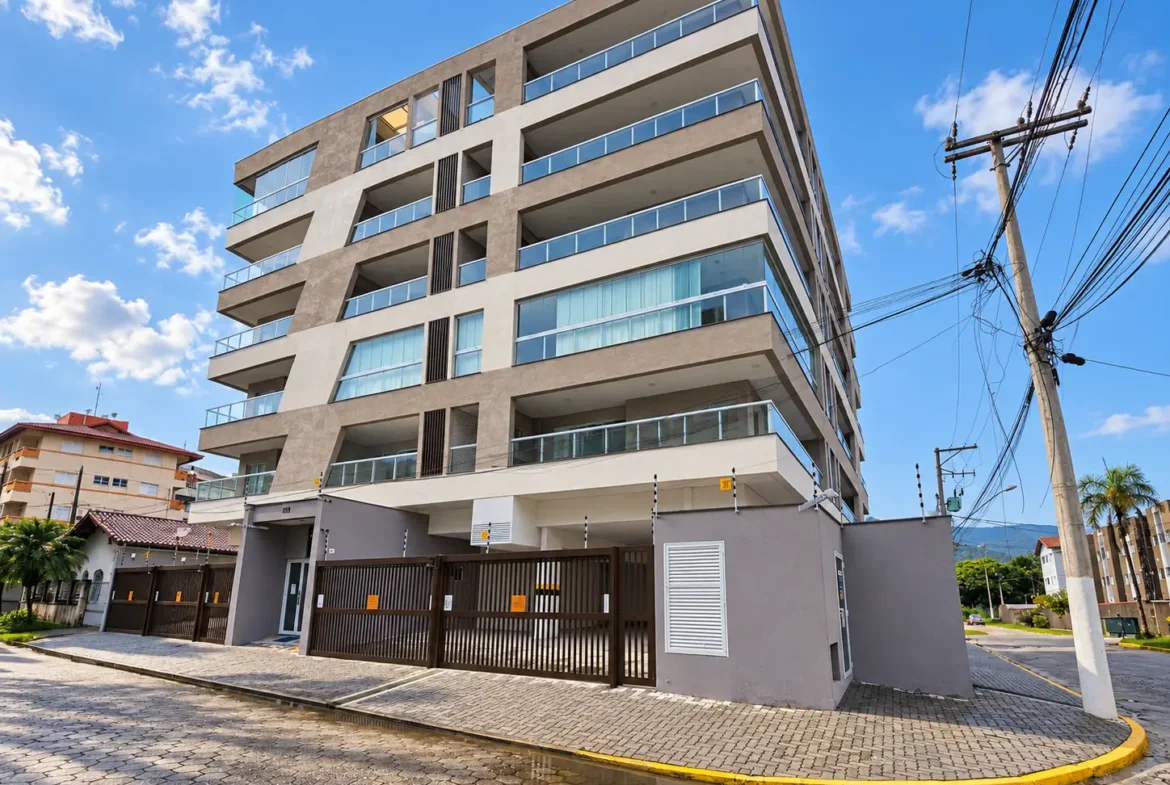 Fachada de edifício de esquina no Itaguá, em Ubatuba, com sacadas e vários pavimentos.