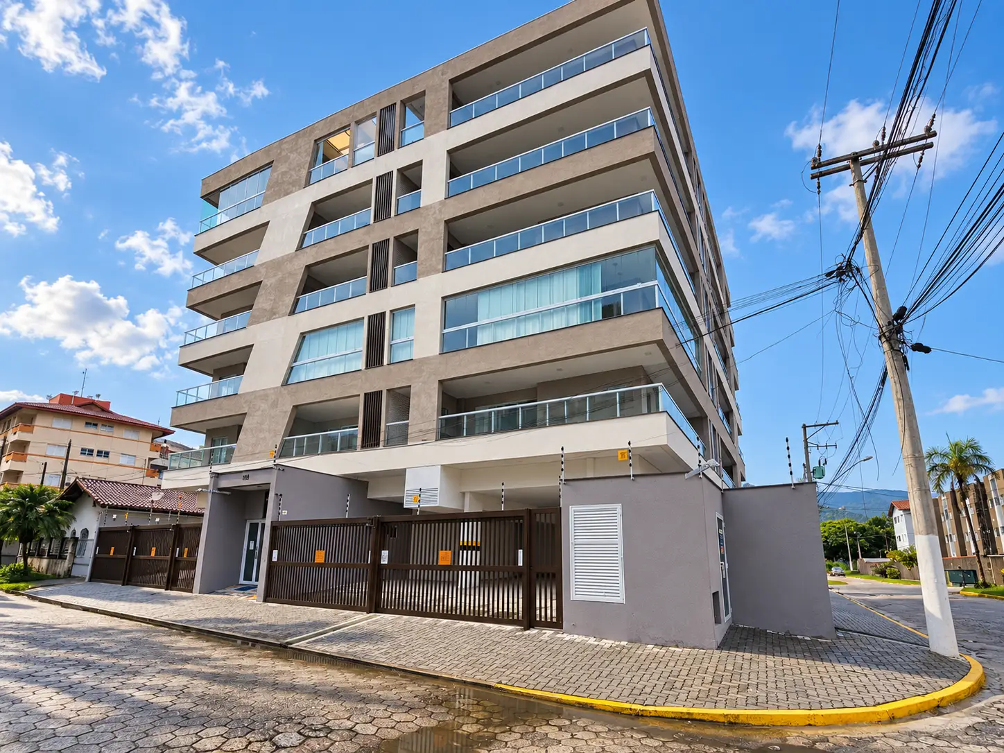 apartamento-itagua-66m2-lg116-fachada-edificio Fachada de edifício de esquina no Itaguá, em Ubatuba, com sacadas e vários pavimentos.