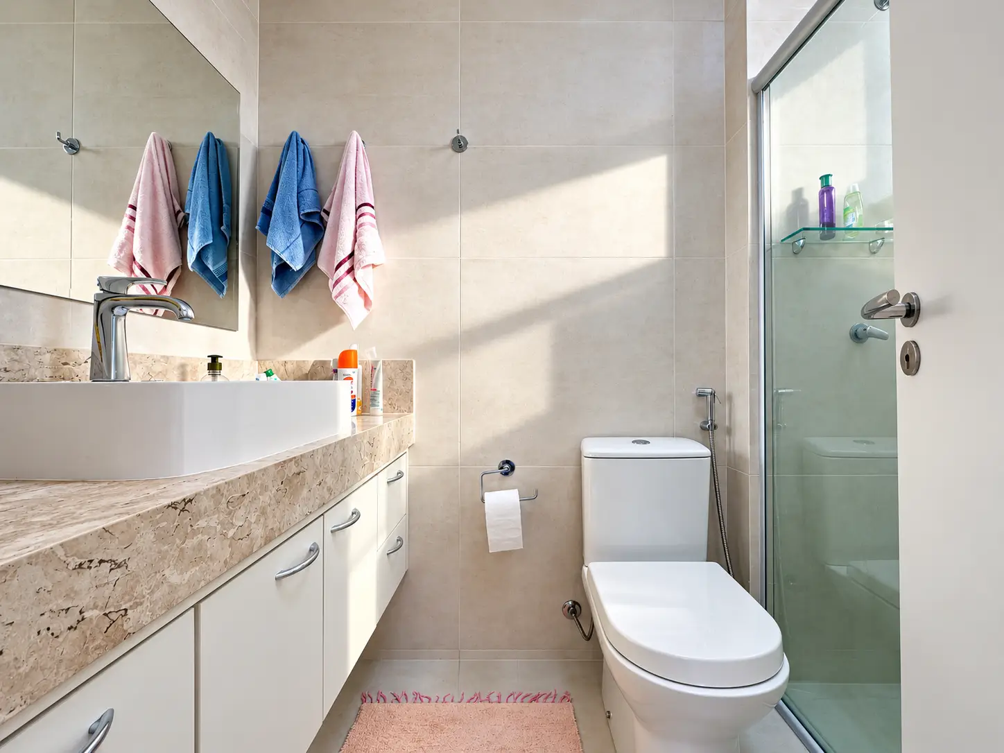 apartamento-itagua-lg117-113-82m2-banheiro Banheiro do apartamento com bancada clara, vaso sanitário, espelho e box de vidro.