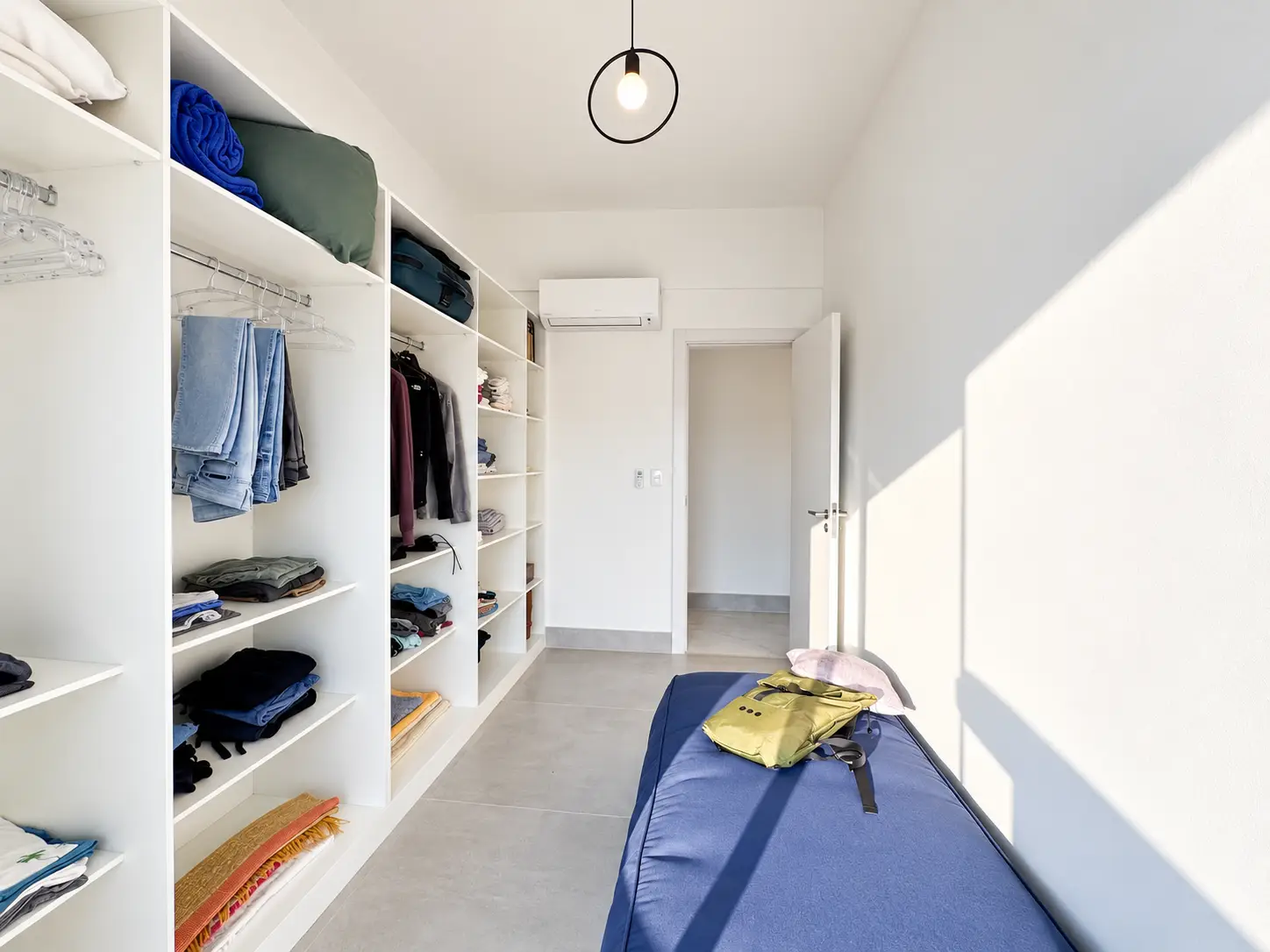 apartamento-itagua-lg117-113-82m2-closet-02 Outro ângulo do closet, com armários planejados nas laterais e corredor central.