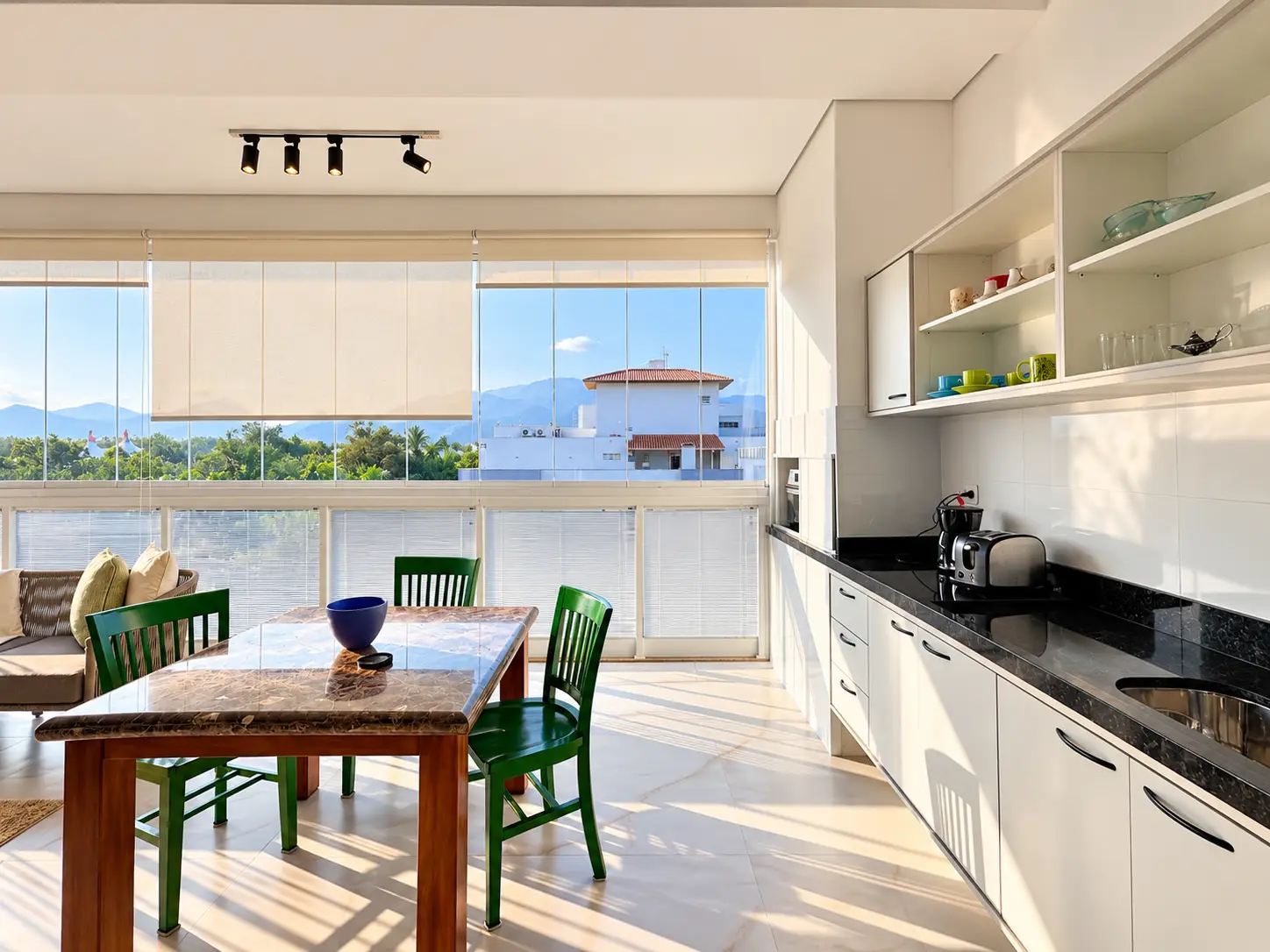apartamento-itagua-lg117-113-82m2-cozinha Cozinha planejada com bancada, armários claros, mesa de jantar e janela ampla.