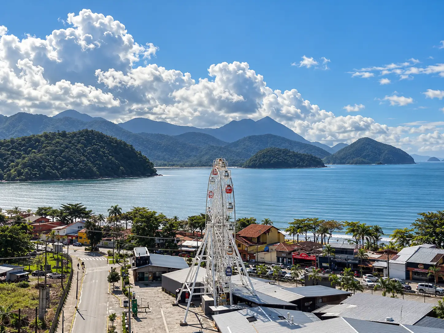 apartamento-itagua-lg117-113-82m2-roda-gigante Vista elevada da região litorânea com roda-gigante, mar e montanhas ao fundo.