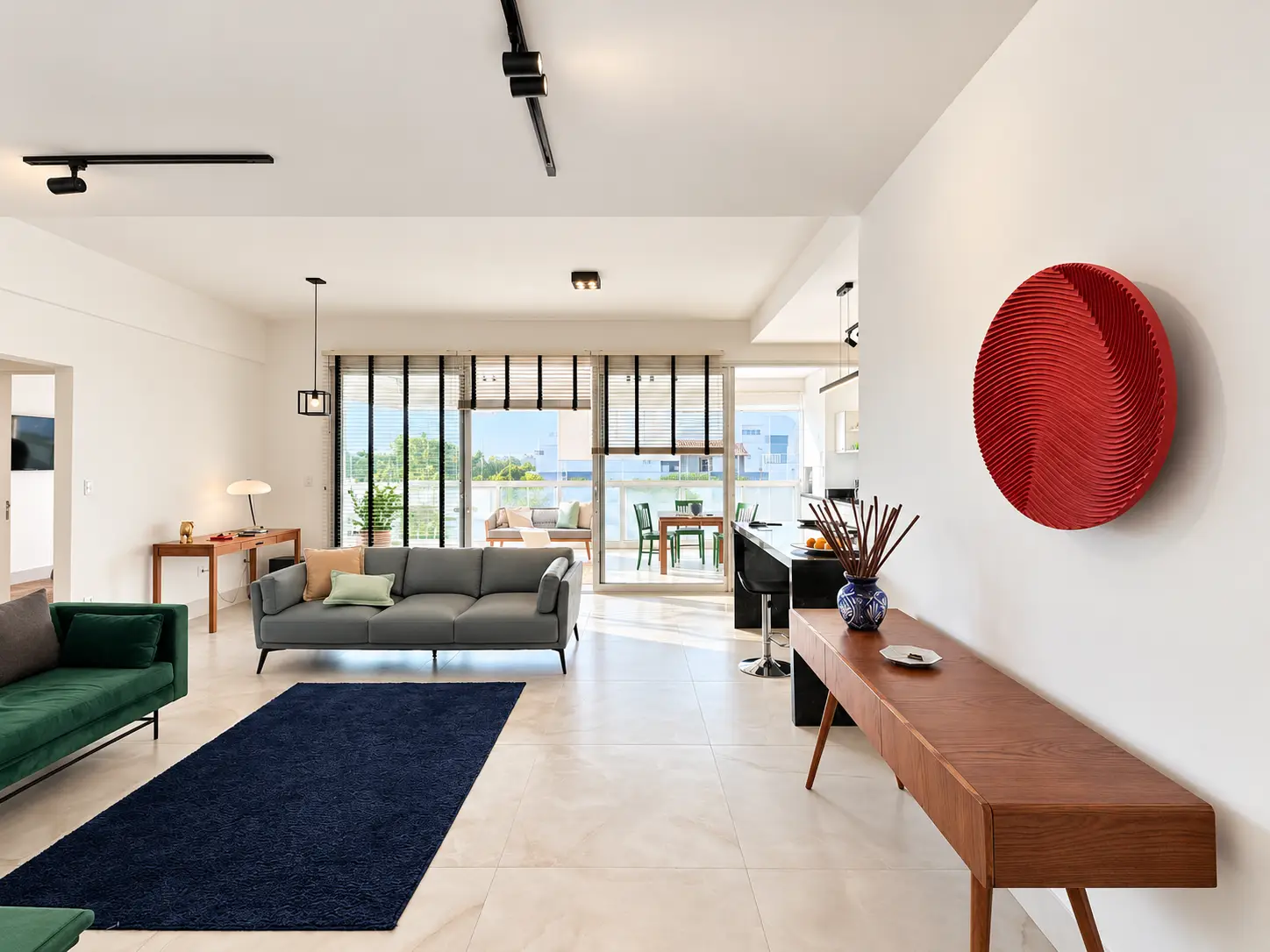 apartamento-itagua-lg117-113-82m2-sala-integrada Vista da sala integrada com sofá, painel decorativo e acesso à varanda.