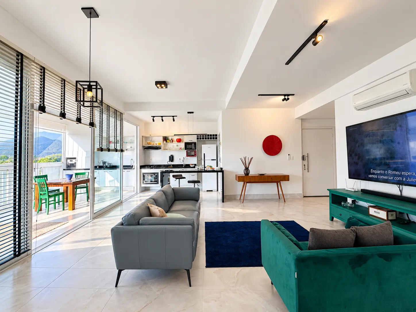 apartamento-itagua-lg117-113-82m2-sala Sala de estar integrada com sofás, televisão, móveis planejados e janelas amplas.