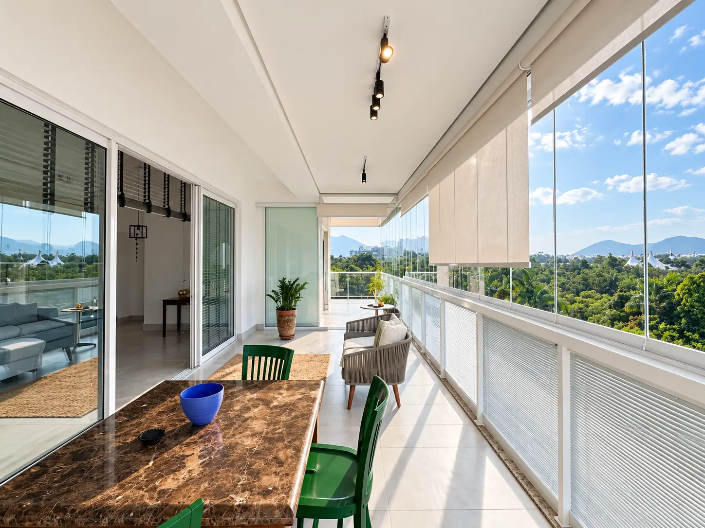 apartamento-itagua-lg117-113-82m2-varanda-vista-montanha Varanda com guarda-corpo de vidro e vista aberta para a vegetação e montanhas.