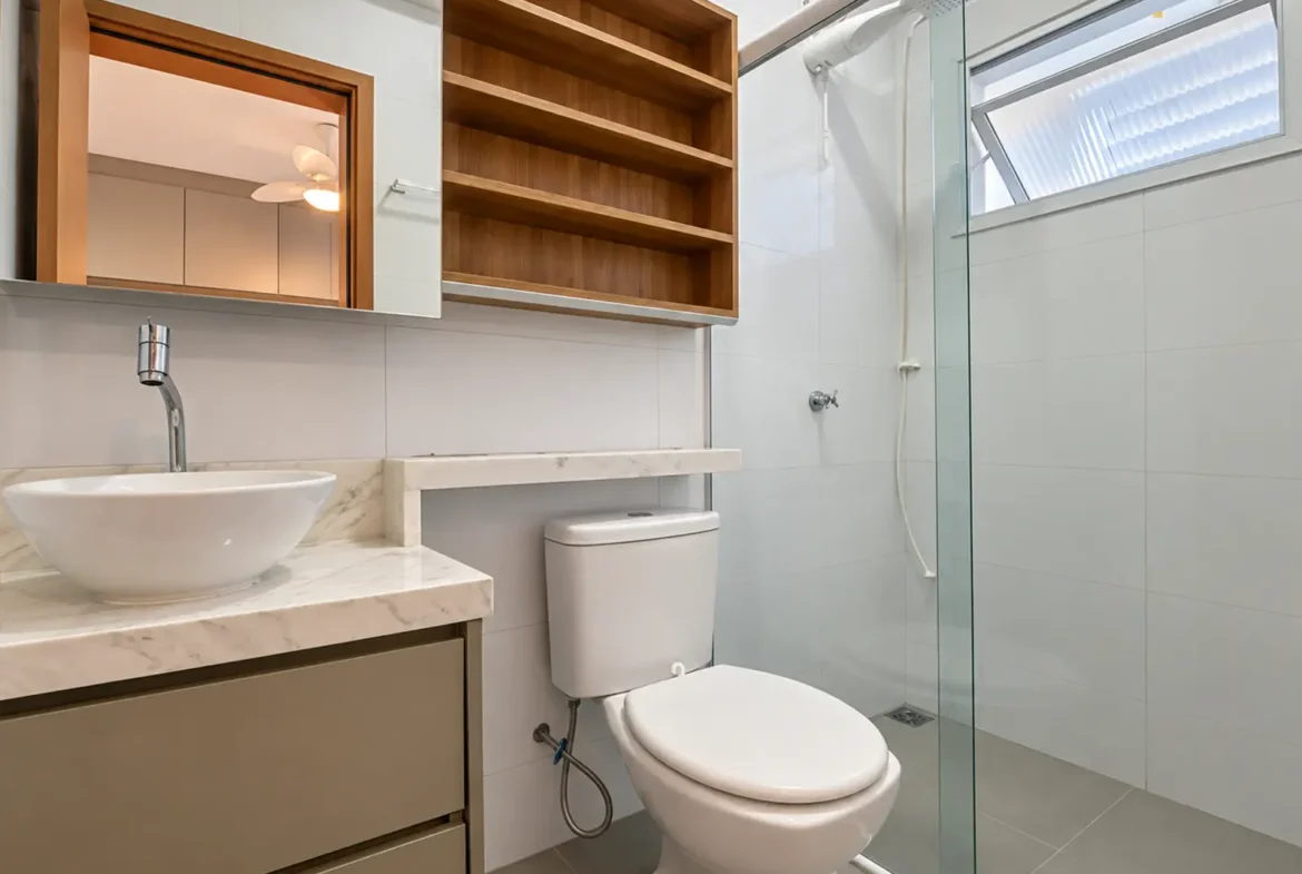 Banheiro do apartamento com box de vidro e armário