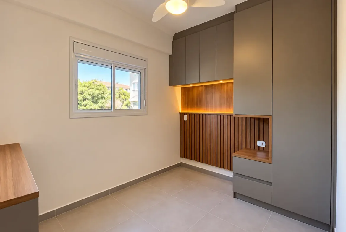 Dormitório do apartamento com janela e armário planejado