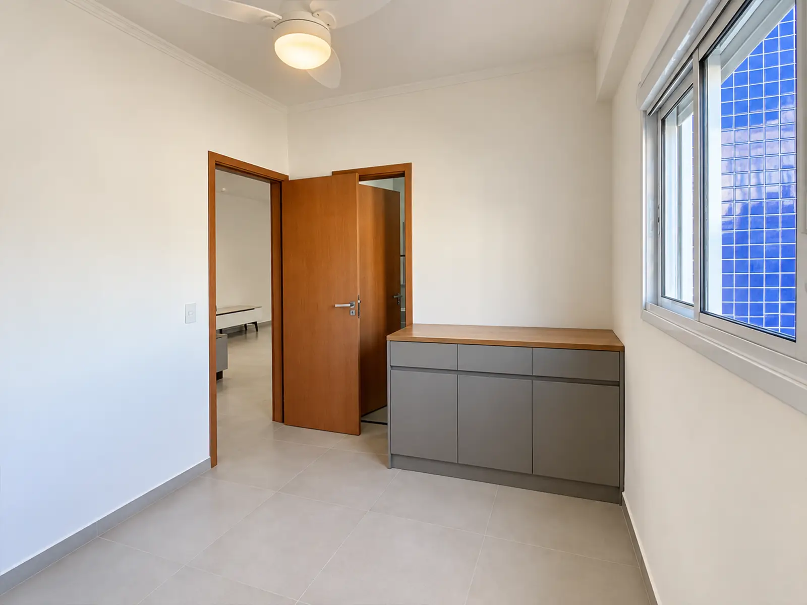apartamento-itagua-ubatuba-90m2-suite Suíte do apartamento com armário planejado e janela