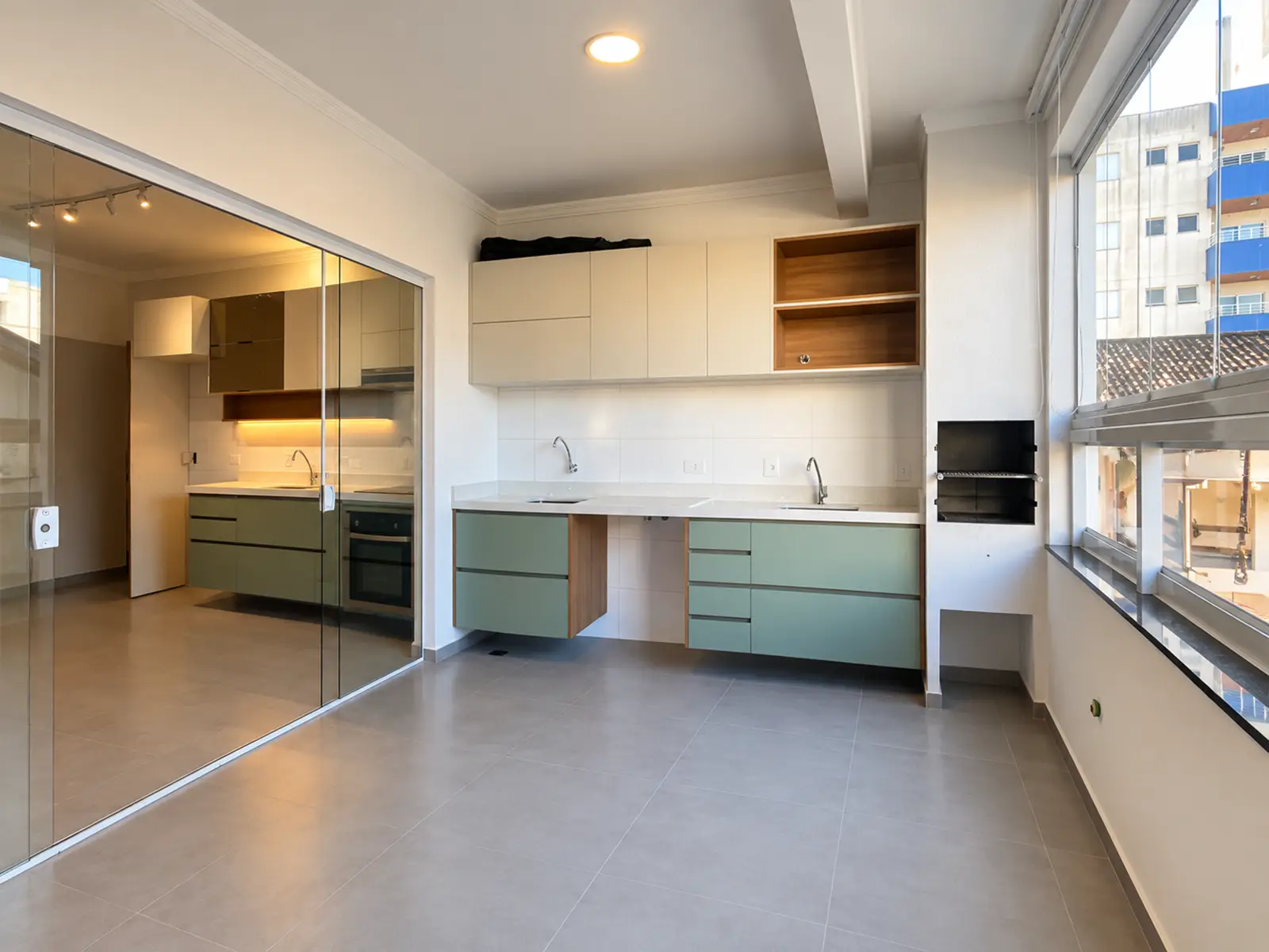 apartamento-itagua-ubatuba-90m2-varanda-com-churrasqueira sala ampla com armários planejados e churrasqueira