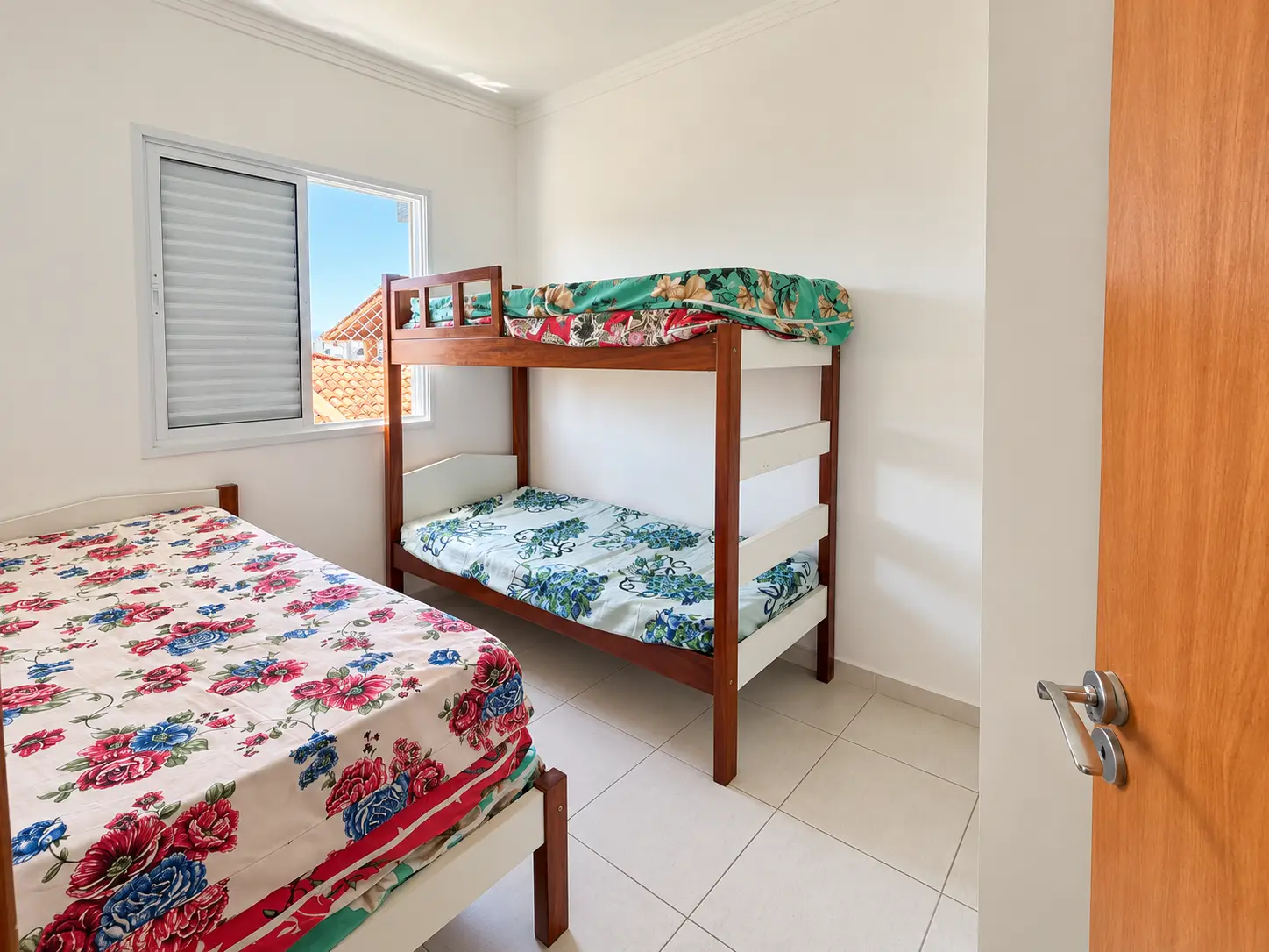 apartamento-praia-grande-dormitorio-02 Segundo dormitório com beliche e roupa de cama estampada.