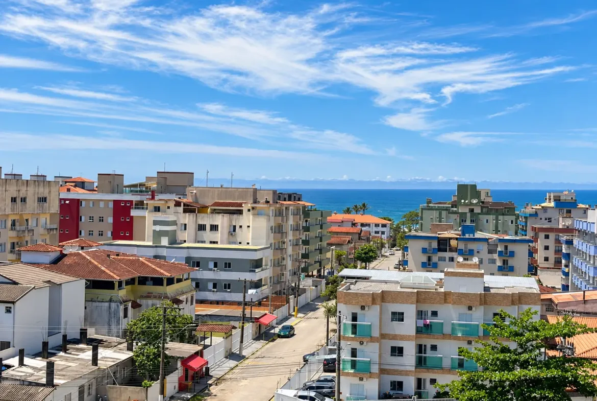 Vista elevada da região urbana com edifícios e o mar ao fundo.