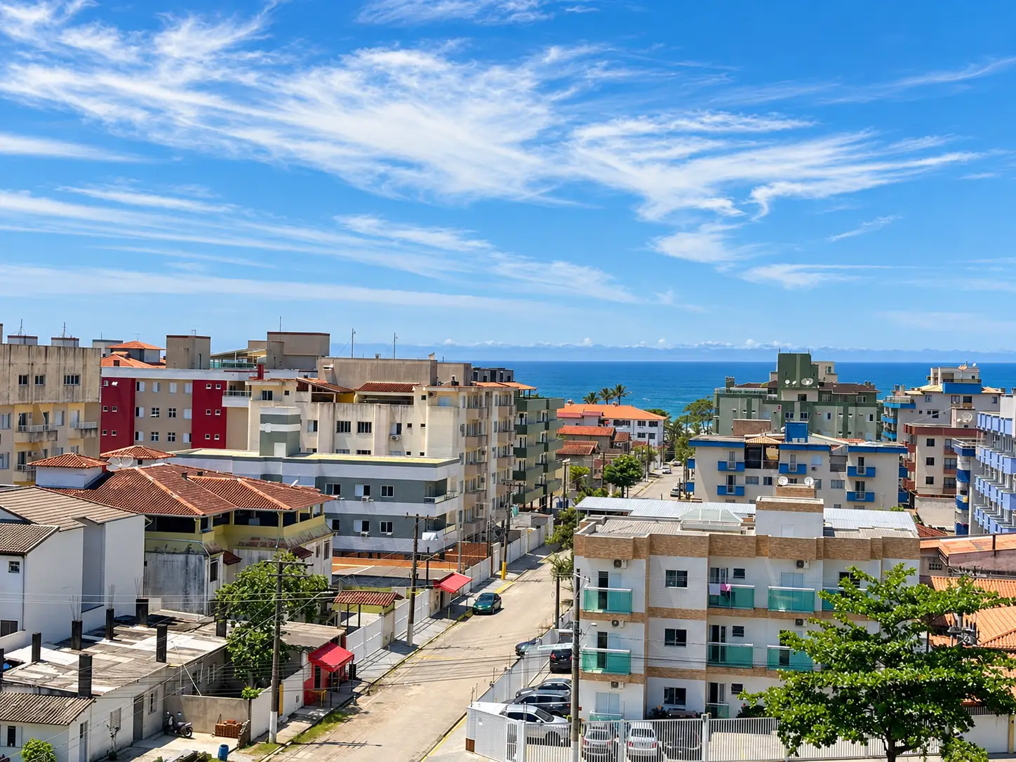 apartamento-praia-grande-vista-praia Vista elevada da região urbana com edifícios e o mar ao fundo.