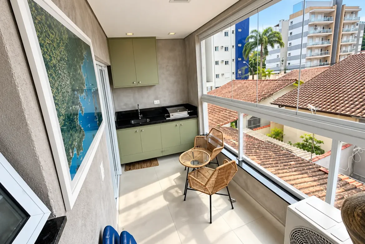 Varanda do loft com mesa, cadeiras e vista para a região urbana.