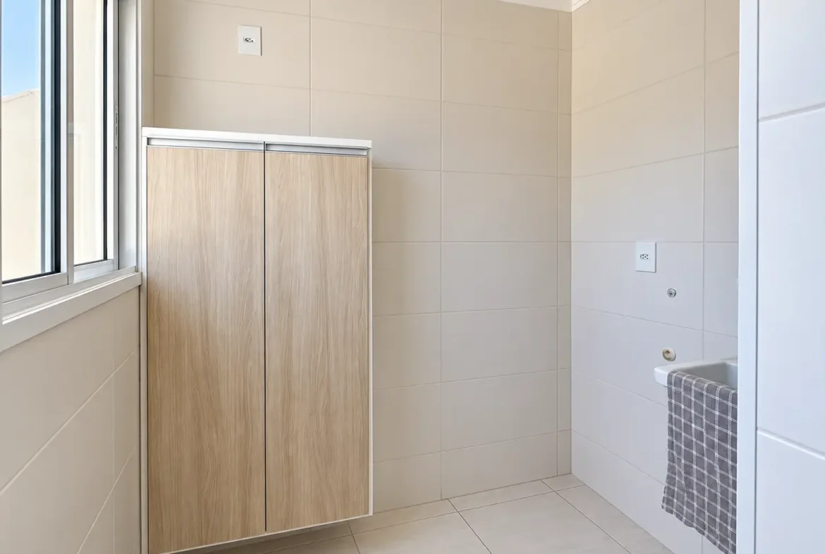 Área de serviço do apartamento com armário e janela.