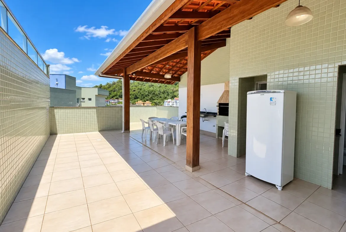 Terraço com churrasqueira, bancada e área coberta por estrutura de madeira.