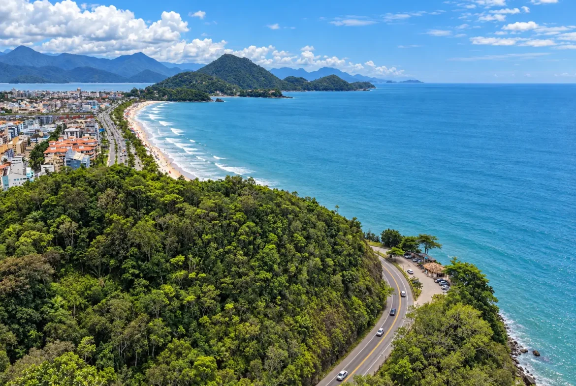 Vista aérea da Praia Grande, em Ubatuba, com praia, vegetação densa e mar azul.